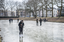 910709 Afbeelding van enkele schaatsers op een bevroren Stadsbuitengracht ter hoogte van de Catharijnesingel te Utrecht.